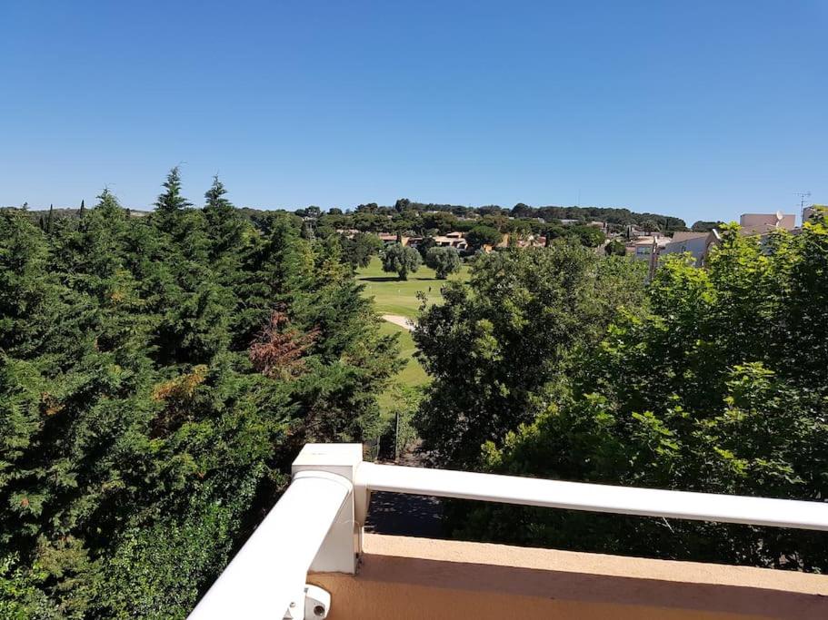 - un balcon avec vue sur une maison arborée dans l'établissement Appartement T3 vue sur Golf, au Cap d'Agde