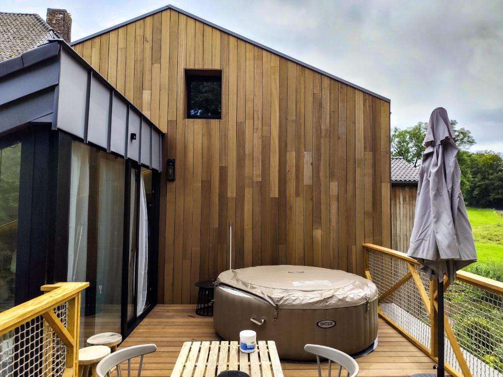 a hot tub on the deck of a house at Marie à la Campagne in Dolembreux