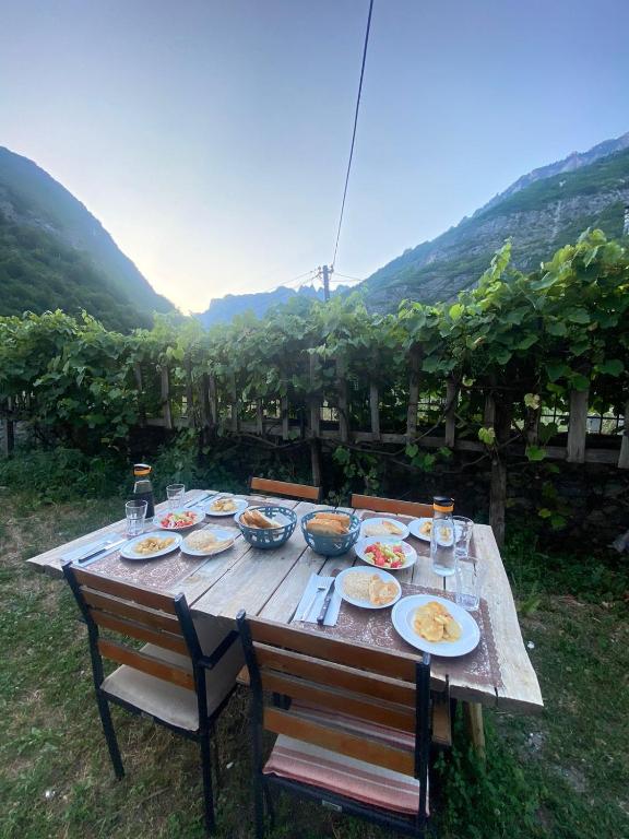 a wooden table with plates of food on it at Guesthouse Sibora in Valbonë