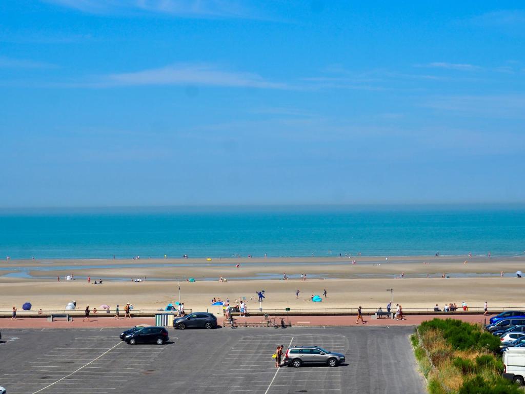 un parcheggio di fronte a una spiaggia con persone di Magnifique appartement T4 vue mer et parking privé a Le Touquet-Paris-Plage