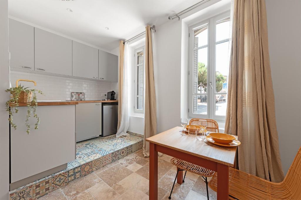 une cuisine et une salle à manger avec une table et une fenêtre dans l'établissement Le Méditerranéen studio proximité Garonne et Capitole, à Toulouse