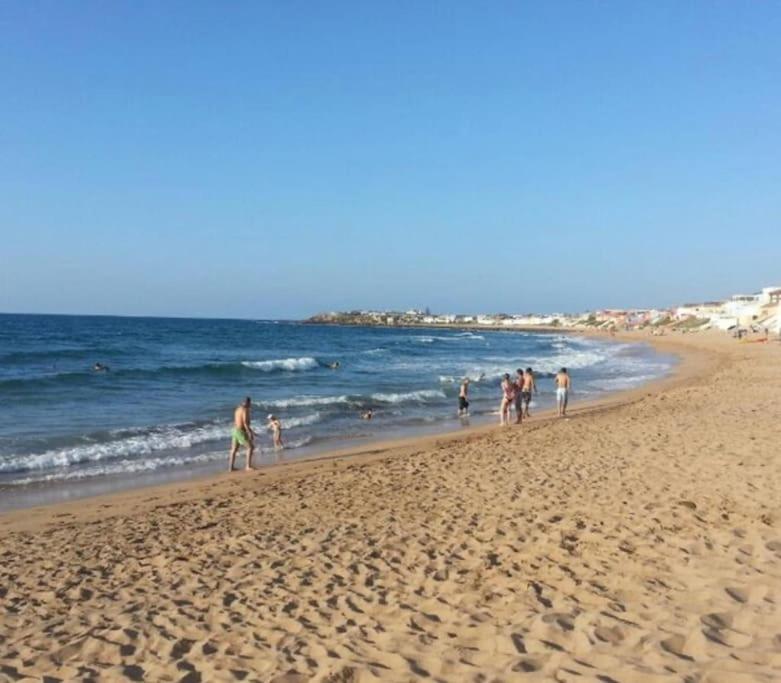 un groupe de personnes marchant sur la plage dans l'établissement Appartement de plage - Dahomey Beach - RDC, à Bouznika