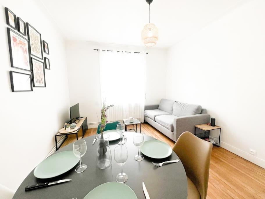 una sala de estar con una mesa y un sofá en T2 Jardin, Centre, Gare, 5'plage, en Saint-Nazaire
