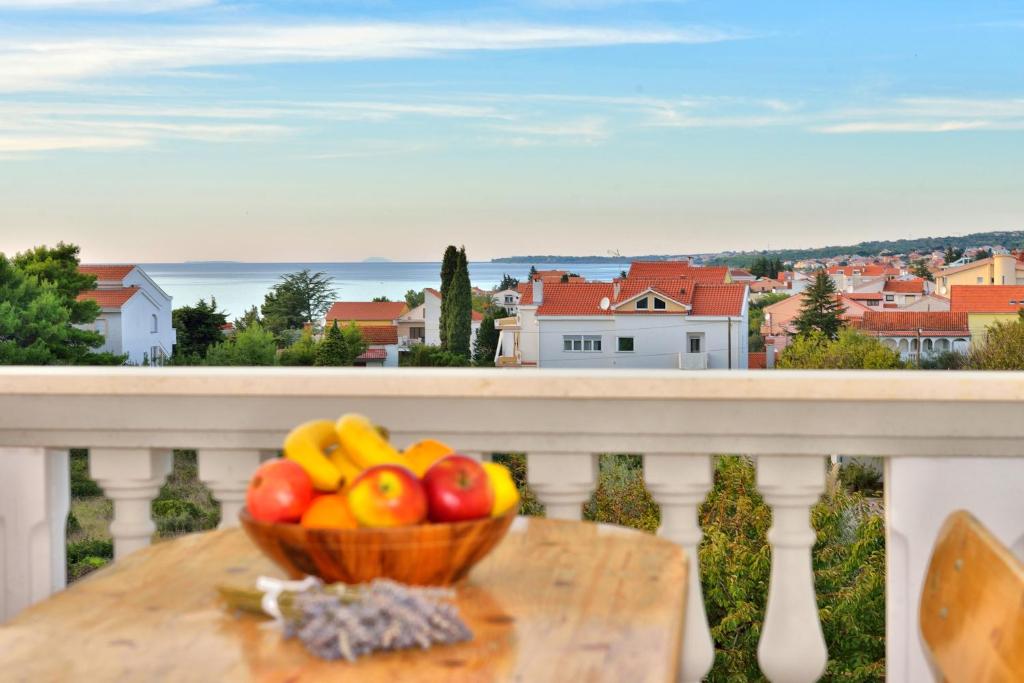 un plato de fruta en una mesa en un balcón en Apartments and a Room Ina, en Zadar