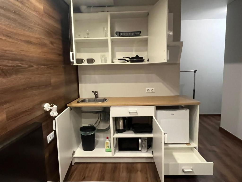 a small kitchen with white cabinets and a sink at EksPorta Apartments 6 in Rīga