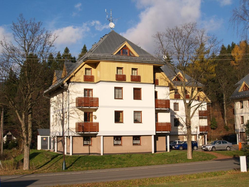 een groot wit huis met een dak bij Rodinné Apartmány in Deštné v Orlických horách