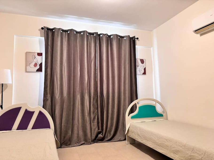 a room with two beds and a curtain at Two Bedroom Luxury Apartment in Larnaka