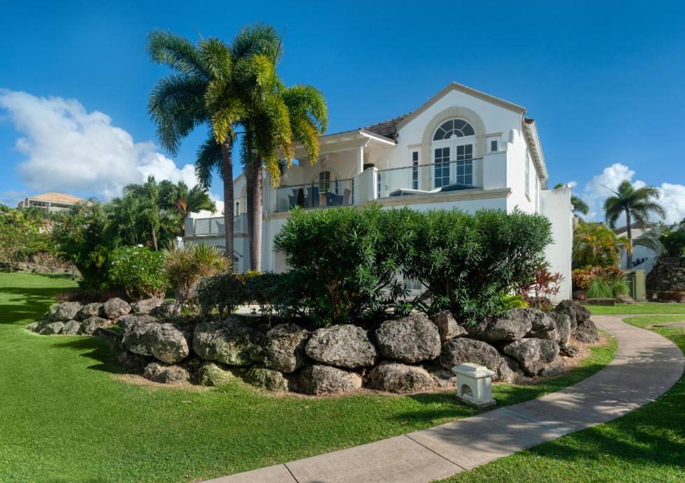 una casa con una palmera y una pared de roca en Royal Villa 17 Royal Westmoreland, en Saint James