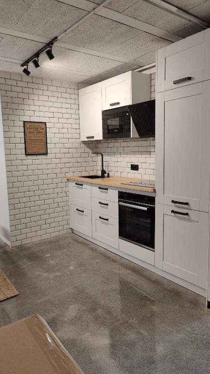 a kitchen with white cabinets and a black oven at Herminia Fariña cerca Sanxenxo in Meaño