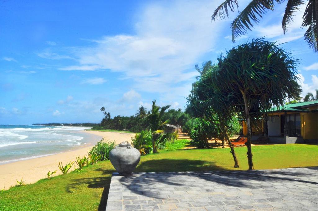 een uitzicht op een strand met een grote vaas op een pad bij The Beach Cabanas Retreat & Spa in Koggala