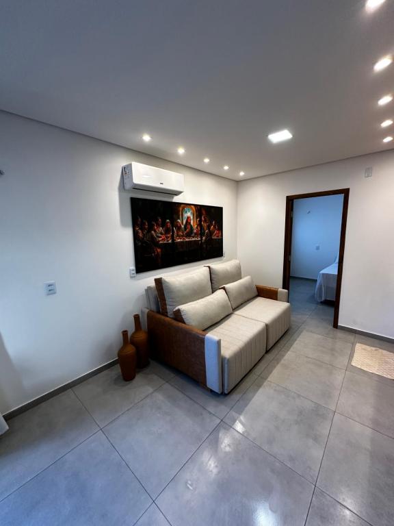 ein Wohnzimmer mit einer Couch und einem Gemälde an der Wand in der Unterkunft Loft Jerimar - beco doce - Jeri in Jericoacoara
