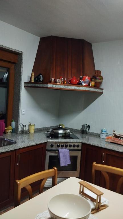 a kitchen with a stove and a table with at Casa Herbellas in Cedeira