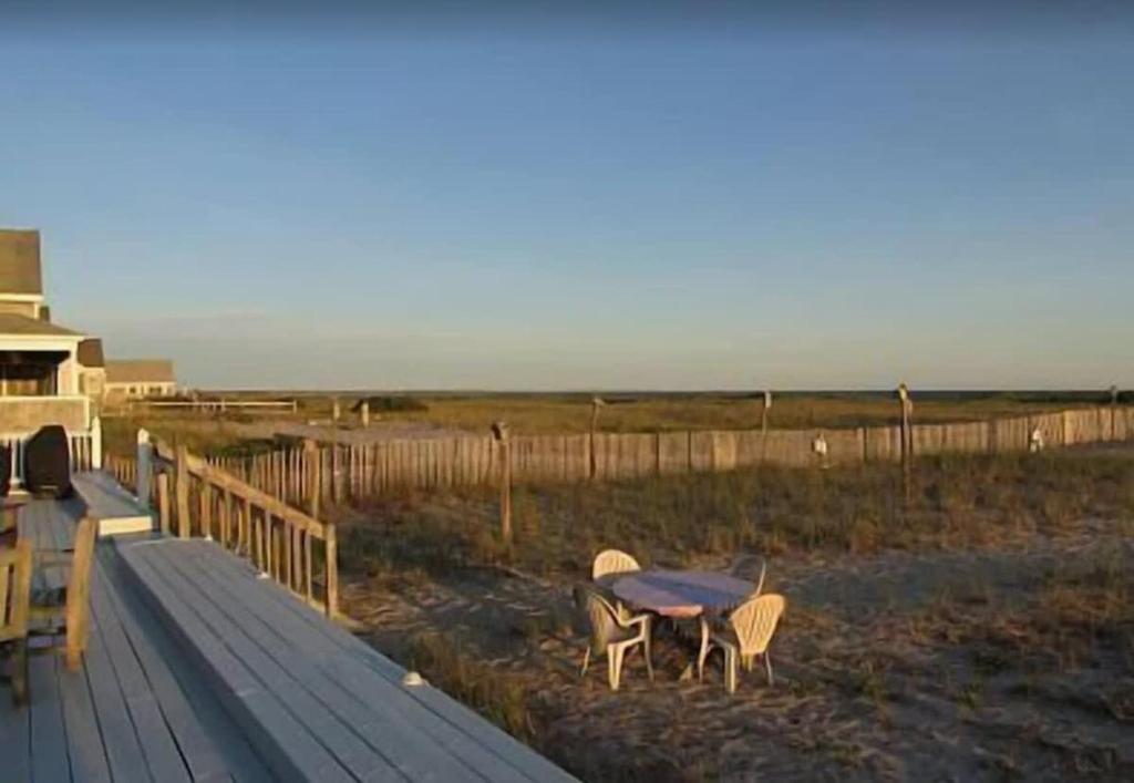 トゥルーロにあるFresh and Crisp Pet Friendly Studioのビーチのそばのデッキに座るテーブルと椅子