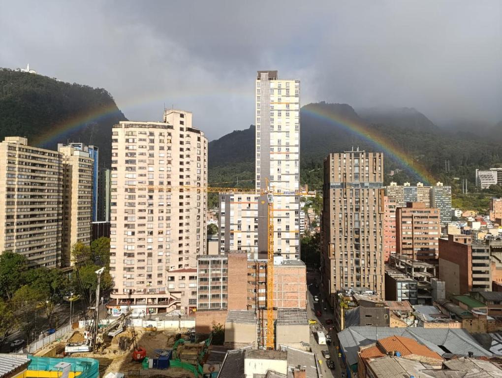 a city with buildings with rainbow in the sky at Comodo Loft con vista al Skyline de Bogotá in Bogotá
