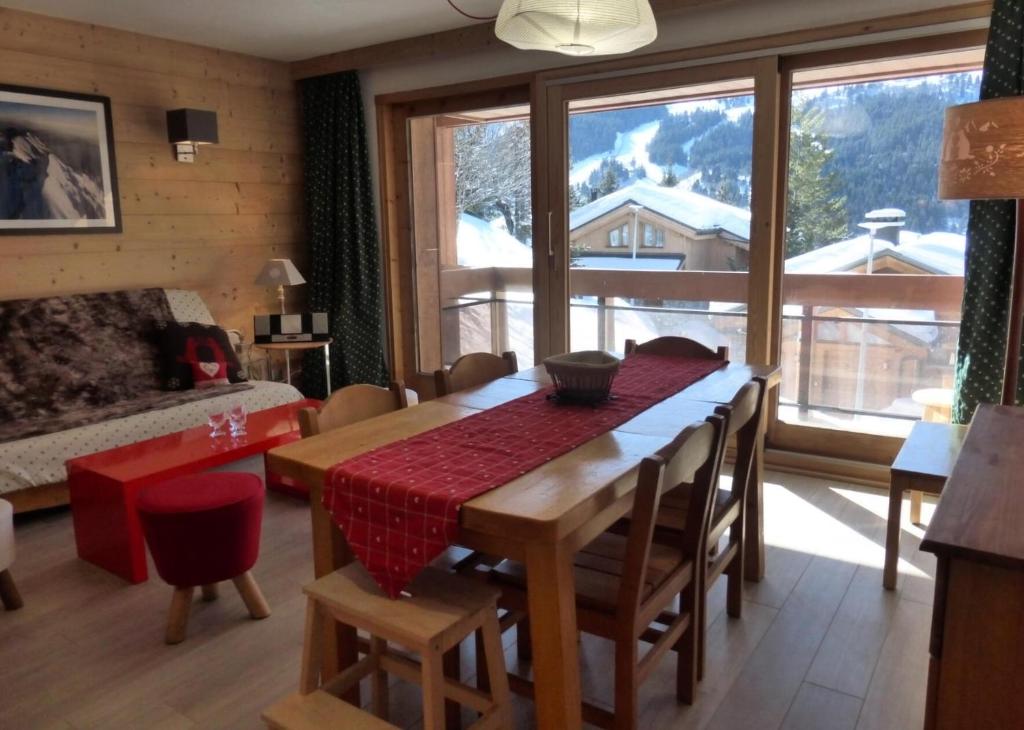 - un salon avec une table à manger offrant une vue dans l'établissement Résidence Trois Marches Bat C - Joli appartement rénové avec une belle vue, proche du télésiège du morel et de l'arrêt de bus MAE-1778, à Les Allues