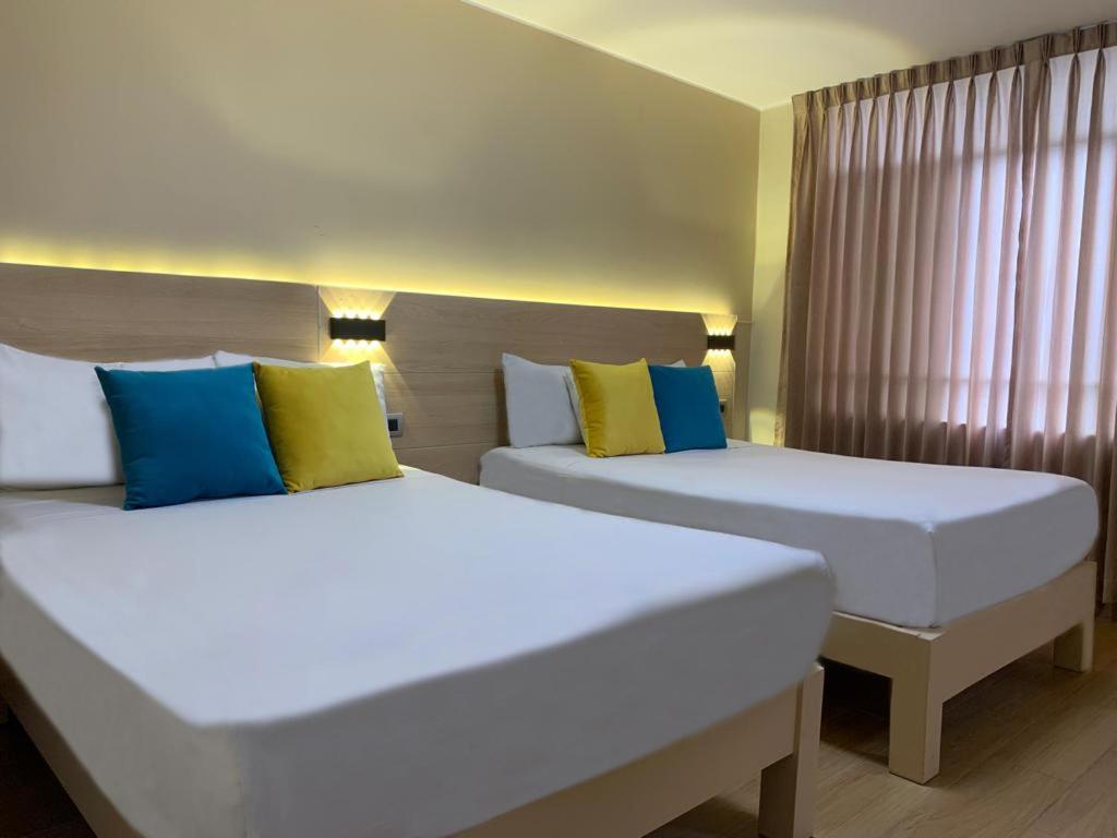 Postel nebo postele na pokoji v ubytování Acuario Hotel & Suite