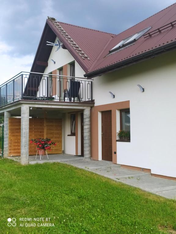 ein Haus mit Balkon und Garten in der Unterkunft Domek NA SKRAJU WSI, APARTAMENTY in Górki Wielkie