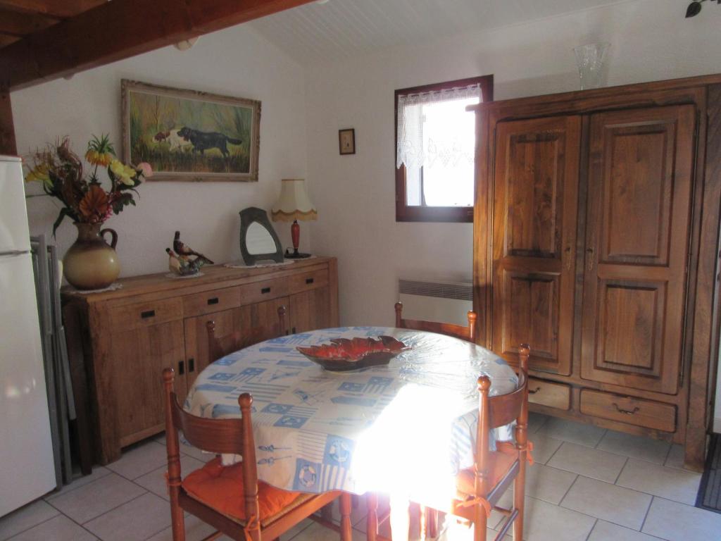 une salle à manger avec une table et un réfrigérateur dans l'établissement jolie maison, aux Mathes