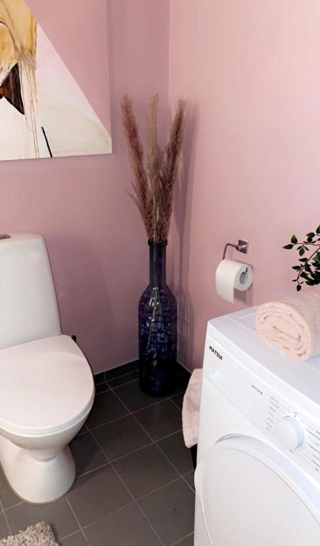 a bathroom with a toilet and a vase with a plant at Apartment for rent ONS in Sandnes