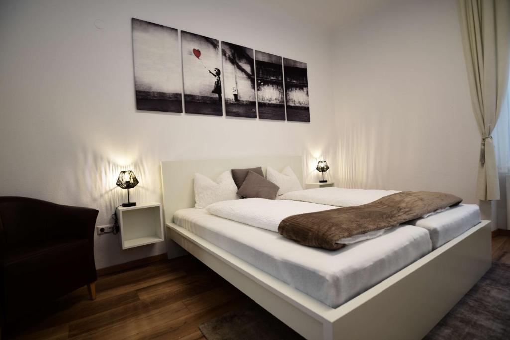 a bedroom with a large white bed with two lamps at Flataid PremiumAPART Graz Center in Graz