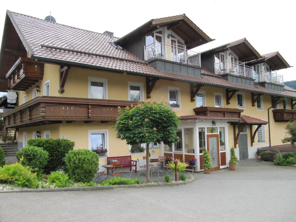 Landgasthof-Hotel Zum Anleitner في Rattenberg: منزل كبير يوجد شرفات فوقه