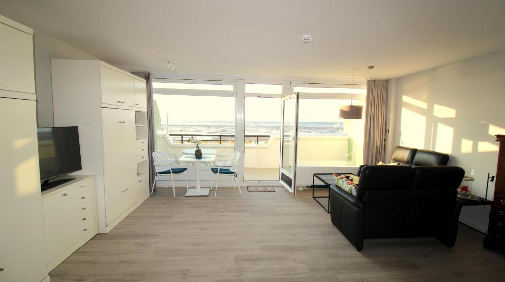 a living room with a couch and a television and a table at Panorama Whg 25, 2 OG in Cuxhaven