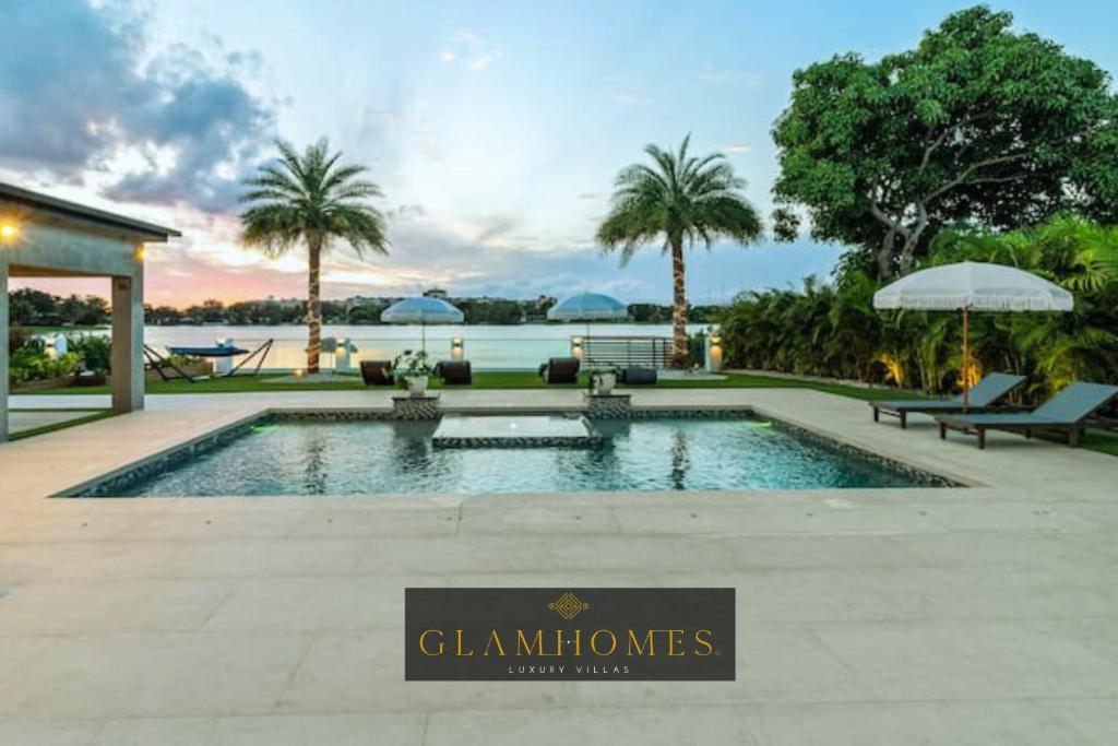 een zwembad met een bord voor een huis bij Waterfront Mansion The GlamHomes in North Miami Beach