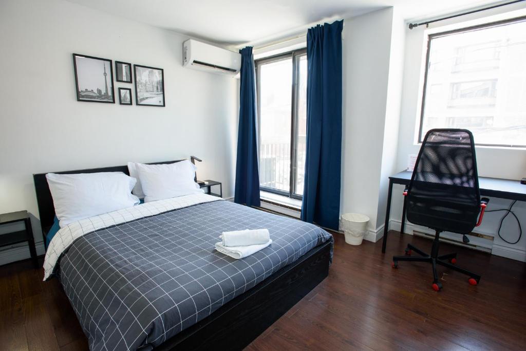 Un dormitorio con una cama, un escritorio y una silla. en Samesun Toronto, en Toronto