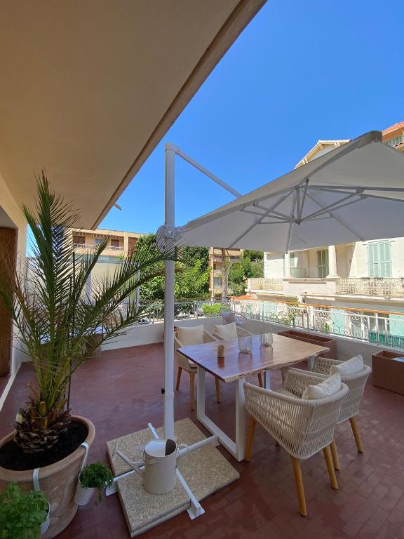 un patio avec une table et un parasol dans l'établissement Sanary- La vie est belle- Centre Ville 2 minutes à pied- Plage 5 minutes, à Sanary-sur-Mer