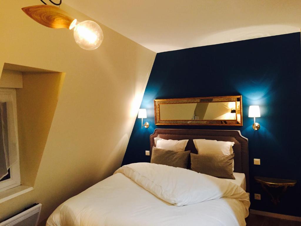 um quarto com uma cama com uma parede azul em Villa Kleber em Estrasburgo