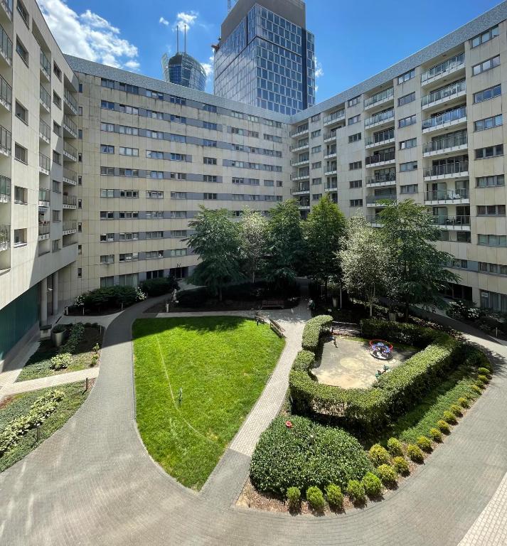 a large building with a garden in front of it at Prime Browary Apartment in Warsaw