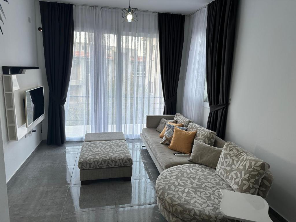 a living room with a couch and a large window at Sessiz tesisi in Kyrenia