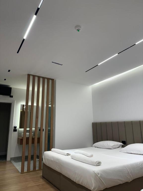 a bedroom with a large bed with white sheets at Hotel Jurgen in Lezhë