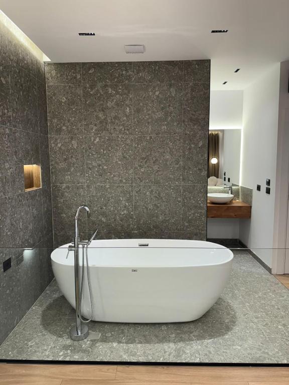 a bathroom with a white tub in a room at Hotel Jurgen in Lezhë