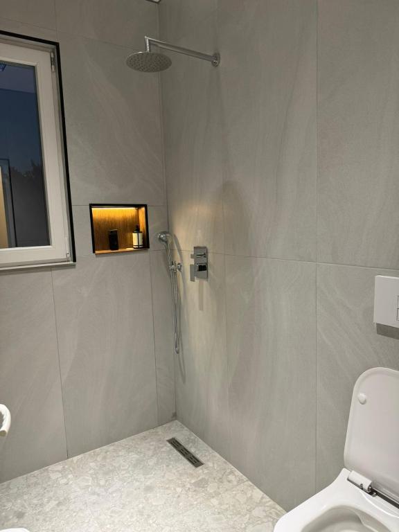 a shower stall in a bathroom with a toilet at Hotel Jurgen in Lezhë