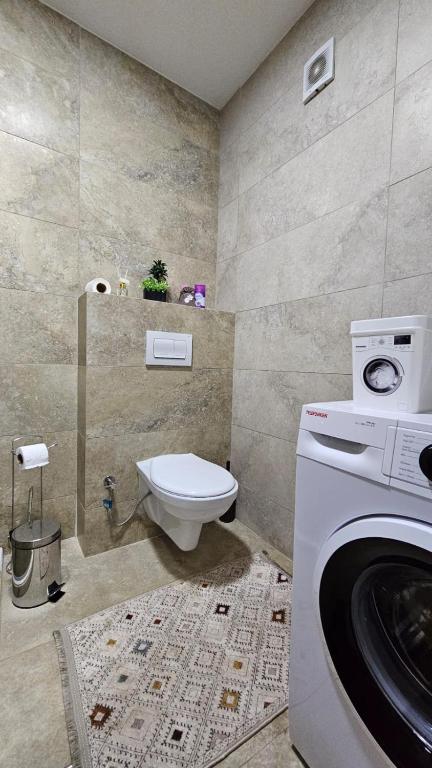 a bathroom with a washing machine and a toilet at Superb 1 bedroom in the best zone of the city. in Ferizaj