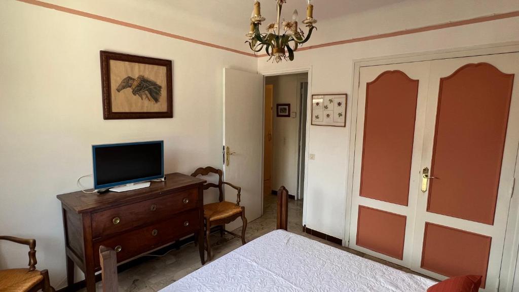 une chambre avec un lit et une télévision sur une commode dans l'établissement Maison typique de provence, à Saint-Rémy-de-Provence