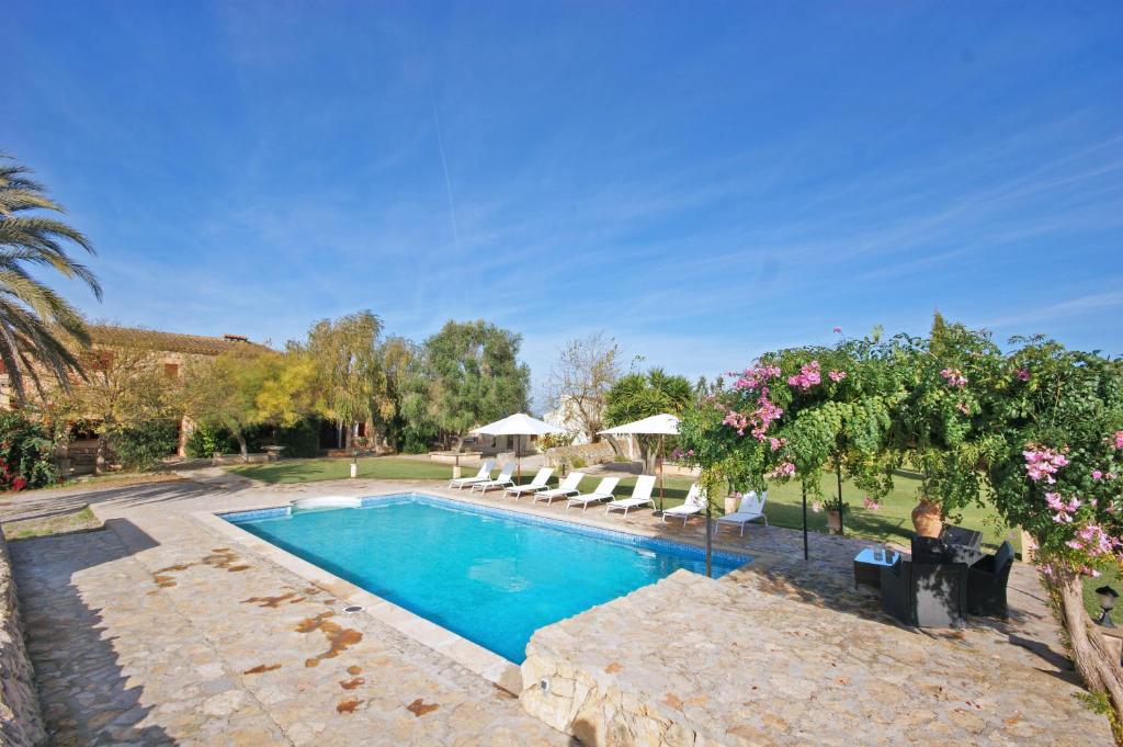 a large white swimming pool in front of a house at Agroturisme Rafal Nou in Manacor