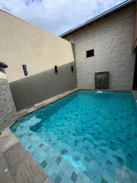 a large swimming pool in front of a building at Área de lazer L&J in Barretos