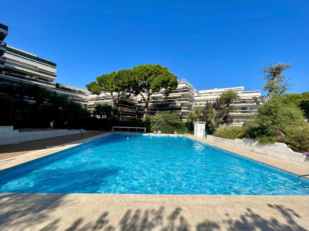 une grande piscine devant un immeuble dans l'établissement Family apartment - Fully equipped, Close to sandy beaches & restaurants, Pool, Balcony, Garage, à Antibes