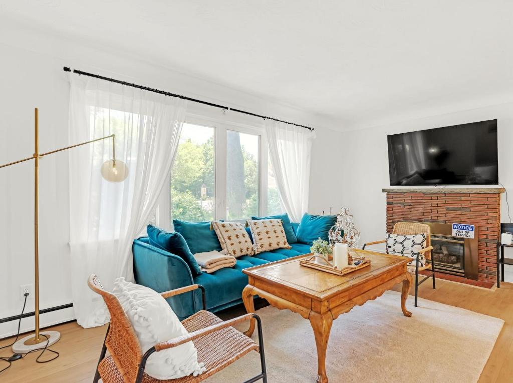 un salon avec un canapé bleu et une table dans l'établissement Walk to Lake - Old Town Retreat, à Niagara on the Lake