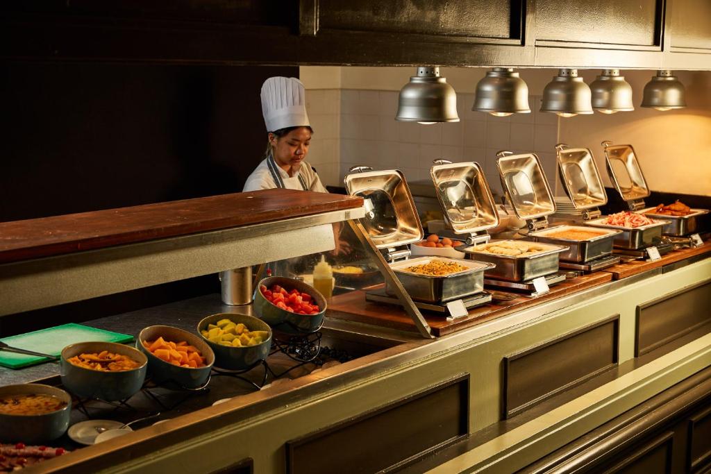 a chef standing in a kitchen preparing food at Stamford Plaza Melbourne in Melbourne