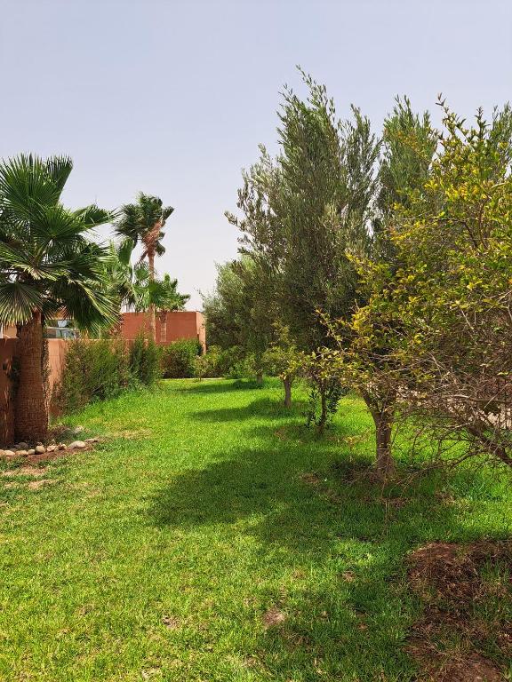 a yard with trees and grass and a building at Atlas Garden Villa in Riaïna
