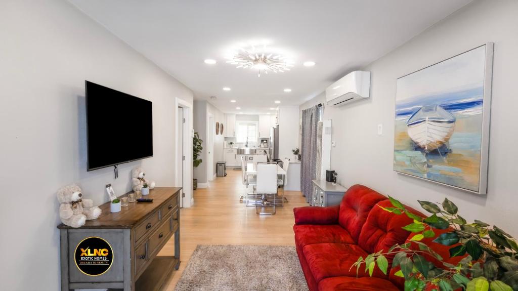 a living room with a red couch and a flat screen tv at Xlnc Exotic Home Lemon Groove in Lemon Grove