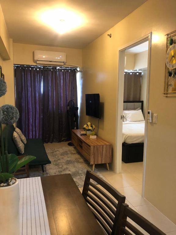 a living room with a room with a bed and a mirror at Majestic One Bedroom Condo Unit in Iloilo City