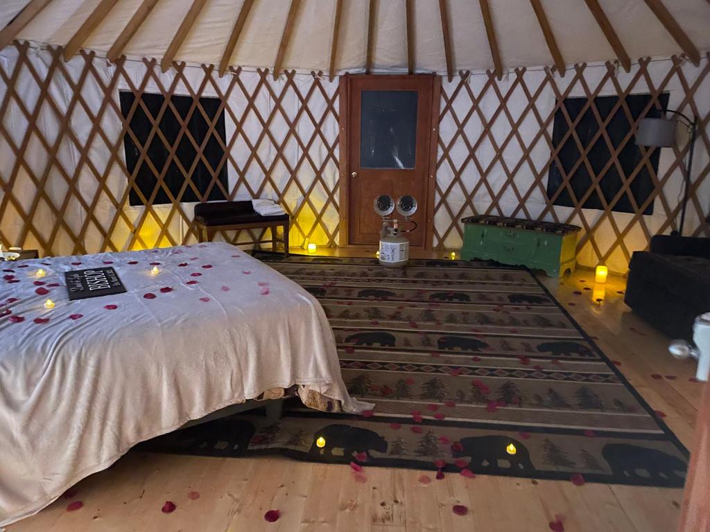 a room with a bed and a large rug in a yurt at Mountain Retreat on Private Lake-Alderbrook Lodge in Bolton