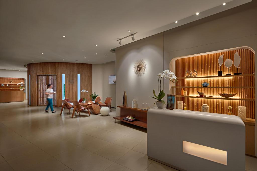 A softly lit lobby with a reception desk, lounge seating and a decorative display wall.