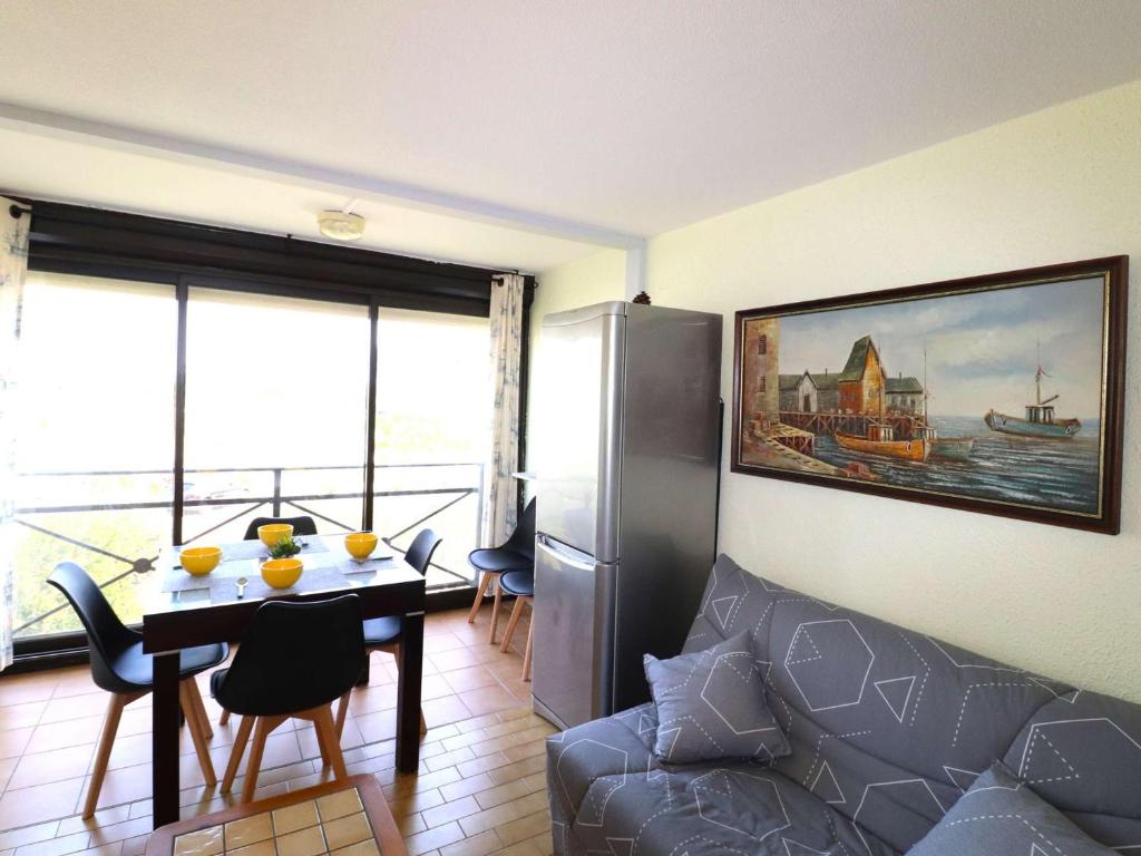 un salon avec une table et un canapé dans l'établissement Appartement 2 pièces avec piscines, proche plage et commerces, parking privé, clim, idéal famille - FR-1-307-273, au Grau-du-Roi
