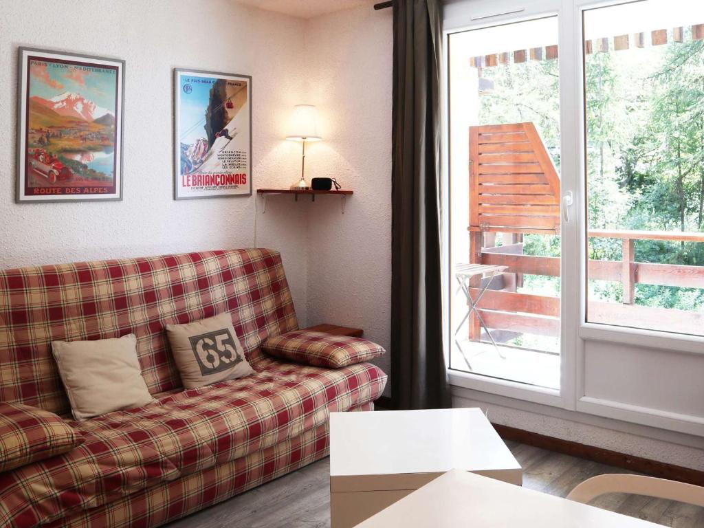 un salon avec un canapé et une fenêtre dans l'établissement Studio cosy pour 4 pers, à 5 min des remontées, quartier calme, balcon, parking disponible - FR-1-322-634, aux Orres