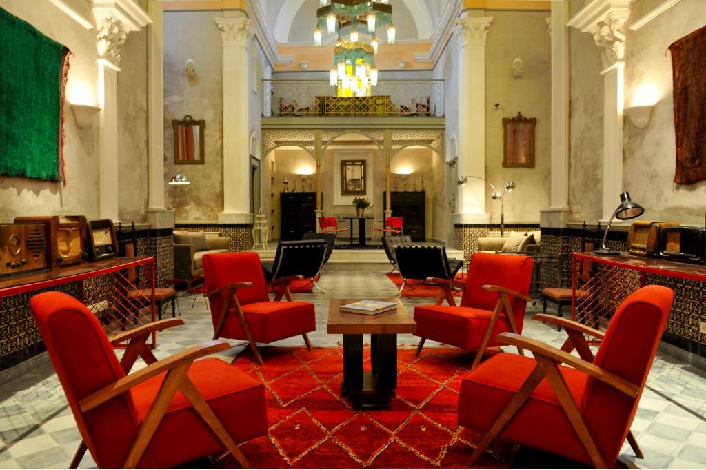 une chambre avec des chaises rouges et une table dans un bâtiment dans l'établissement Hotel L'Iglesia, à El Jadida